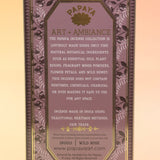 The Wild Rose Premium Incense on a pink and yellow background, showing off the back.