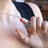 Someone wearing the Morgana's Spell Sterling Silver Necklace with a black top.