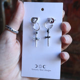 Someone holding the Silver Sword Hoop Earrings while they are on their card.