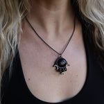 Someone wearing the Priestess Obsidian Brass Necklace.
