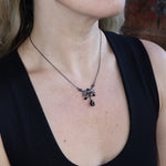 Someone wearing the Dark Fae Brass Plated Necklace with a black tank.