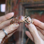 Someone holding the Gold Medusa Cuff Bracelet.