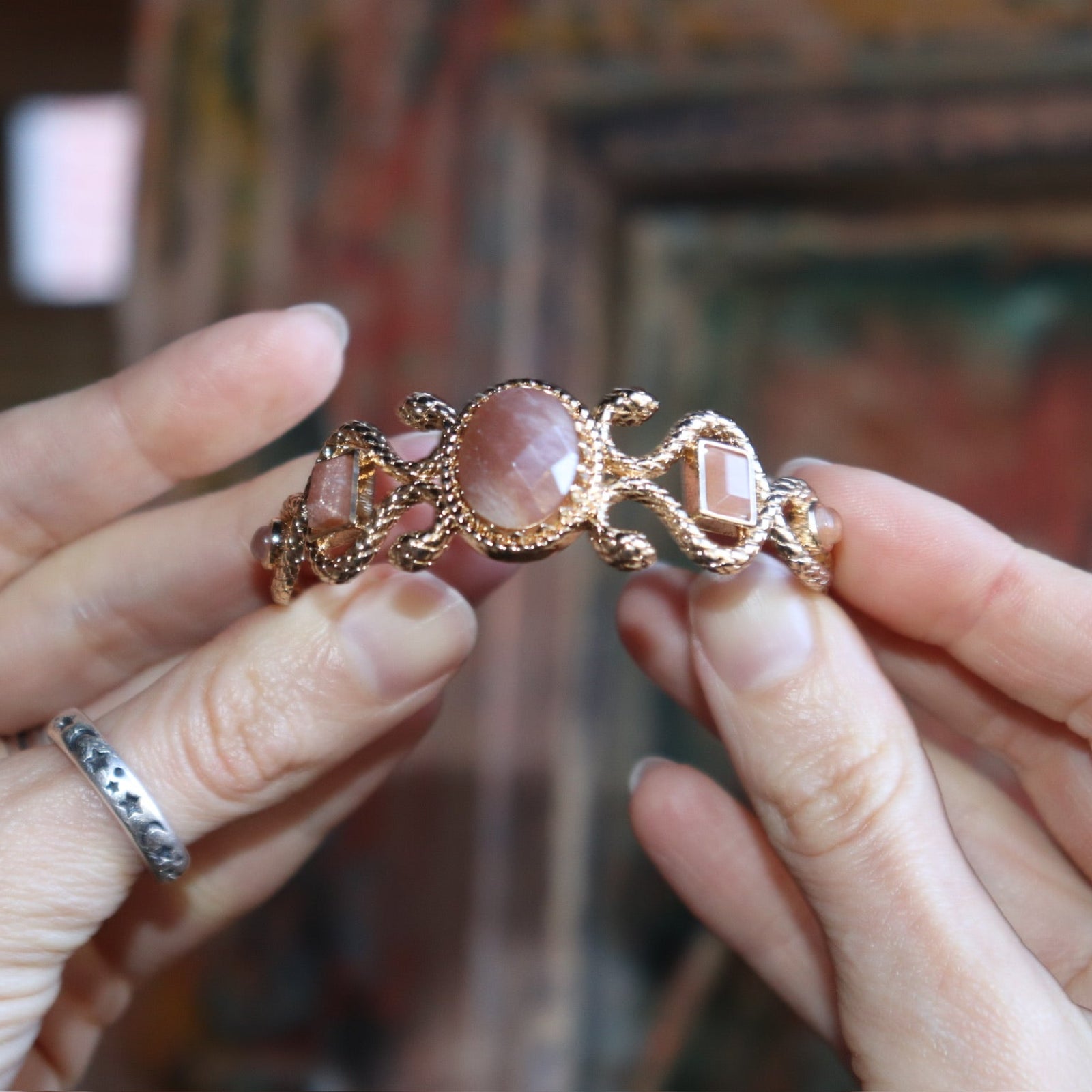 Someone holding the Gold Medusa Cuff Bracelet.