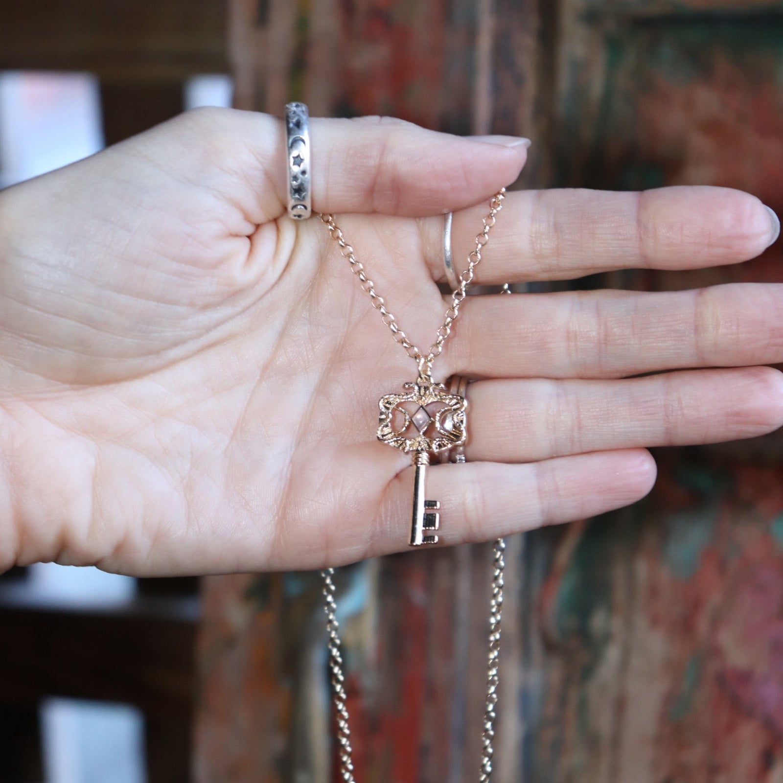 Someone holding the Hecate's Key Gold Amethyst Necklace.