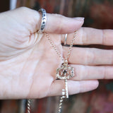 Someone holding the Hecate's Key Gold Amethyst Necklace, showing off the back.