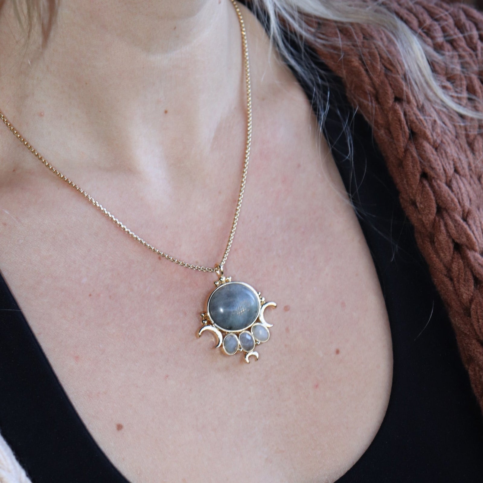 Someone wearing the labradorite Priestess Gold Brass Necklace with a black tank.
