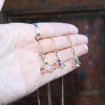 Someone holding all three of the Fae Crystal Gold Necklaces.