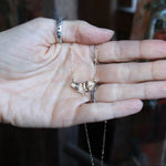Someone holding the The Moon Moth Dainty Gold Necklace.