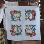 Someone holding up the Tomato Ivory Cotton Bandana in front of a wooden door.