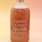 The Candy Cane Sparkle Cocktail & Mocktail Mixer on a pink and yellow background.