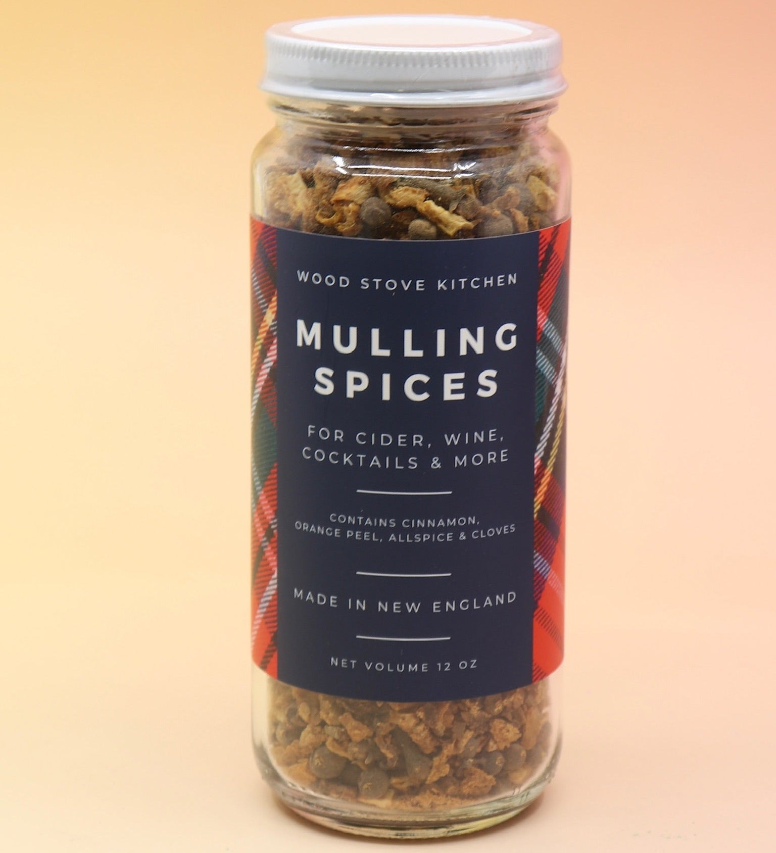 The Mulling Spices bottle on a pink and yellow background.
