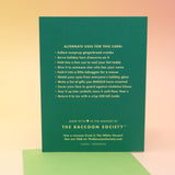 The back of the Act Like We're Not High Christmas Card on a pink and yellow background.