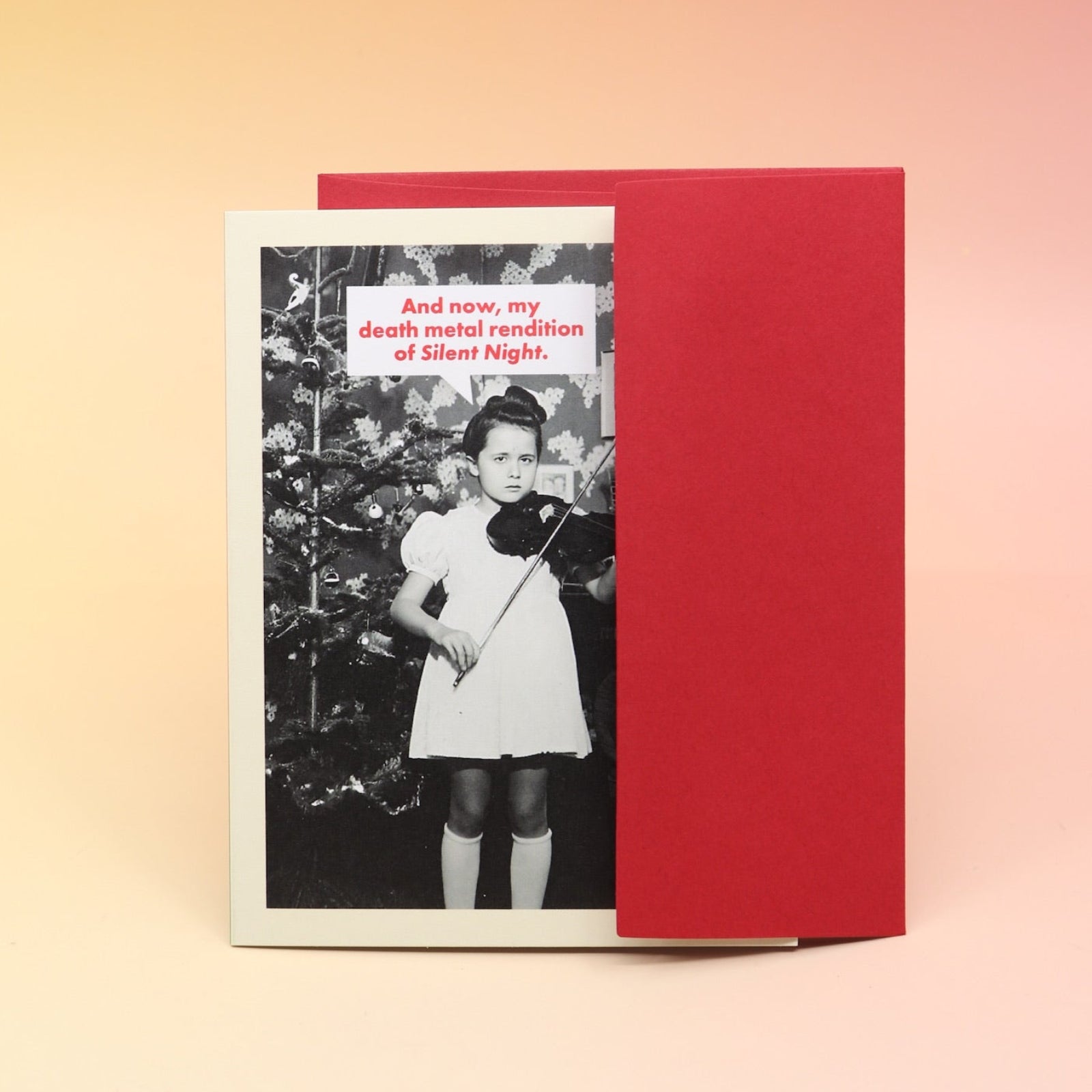 The Death Metal Christmas Card with its envelope on a pink and yellow background.