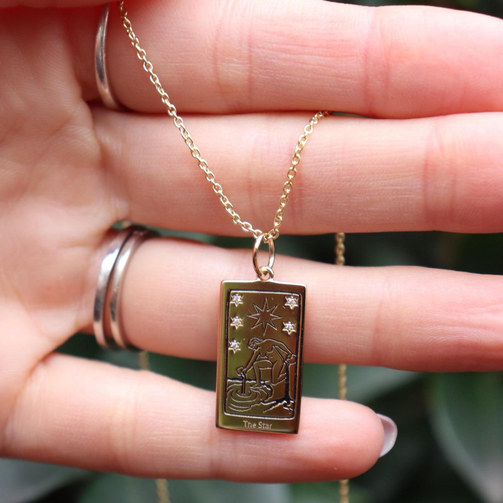 Someone holding the Star Tarot Gold Necklace.