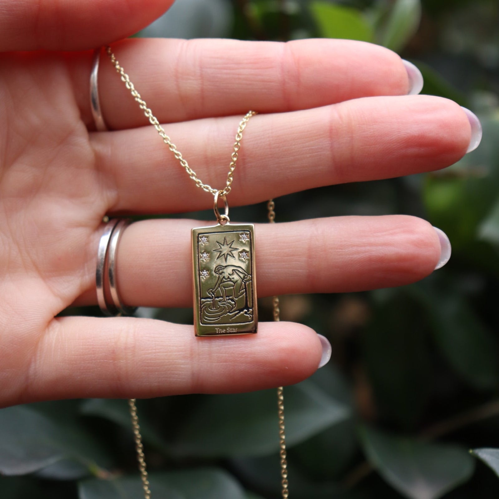 Someone holding the Star Tarot Gold Necklace.