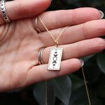 Someone holding the Star Tarot Gold Necklace, showing off the back.