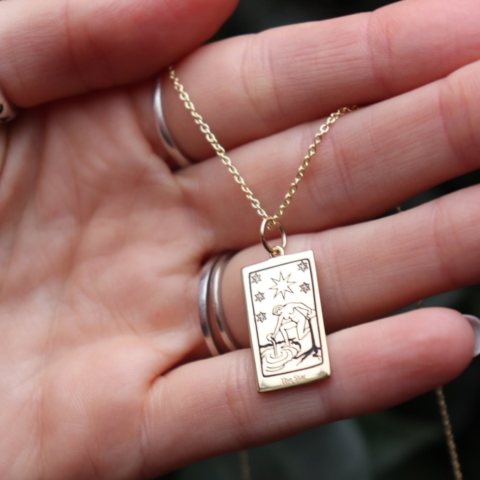 Someone holding the Star Tarot Gold Necklace.