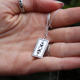 Someone holding the The Lovers Tarot Sterling Silver Necklace.