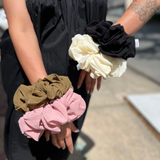 Someone wearing all four XL Jumbo Chiffon Scrunchies on their wrists.