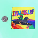 The Truckin Grateful Dead Sparkle 3 Inch Sticker next to a quarter on a green background.