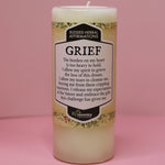 The Affirmation Grief Candle - Pillar Candle with Cypress Blend on a pink background.