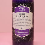 The Astro Magic Jupiter - Lucky Star Pillar Candle on a pink background.