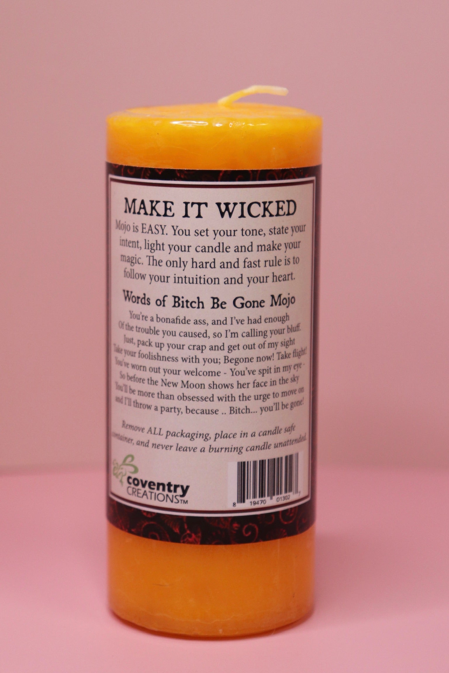 The back of the Wicked Witch Mojo Bitch Be Gone- Scented Pillar Candle on a pink background.