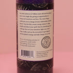 The back of the Astro Magic Jupiter - Lucky Star Pillar Candle on a pink background.