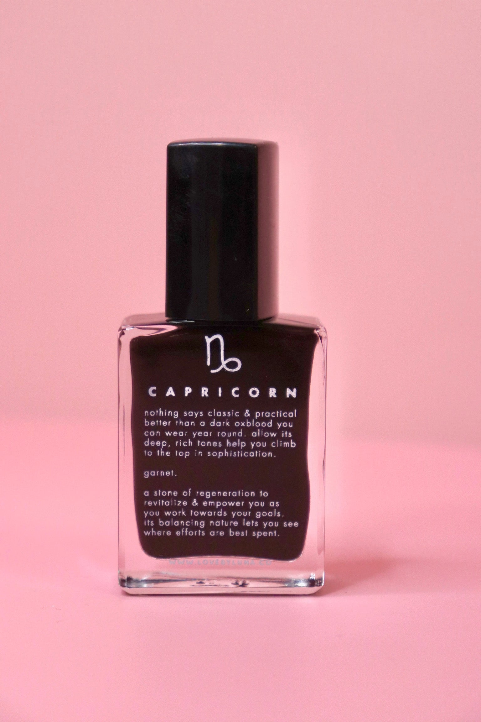The Capricorn Zodiac Nail Polish with Micronized Garnet on a pink background.