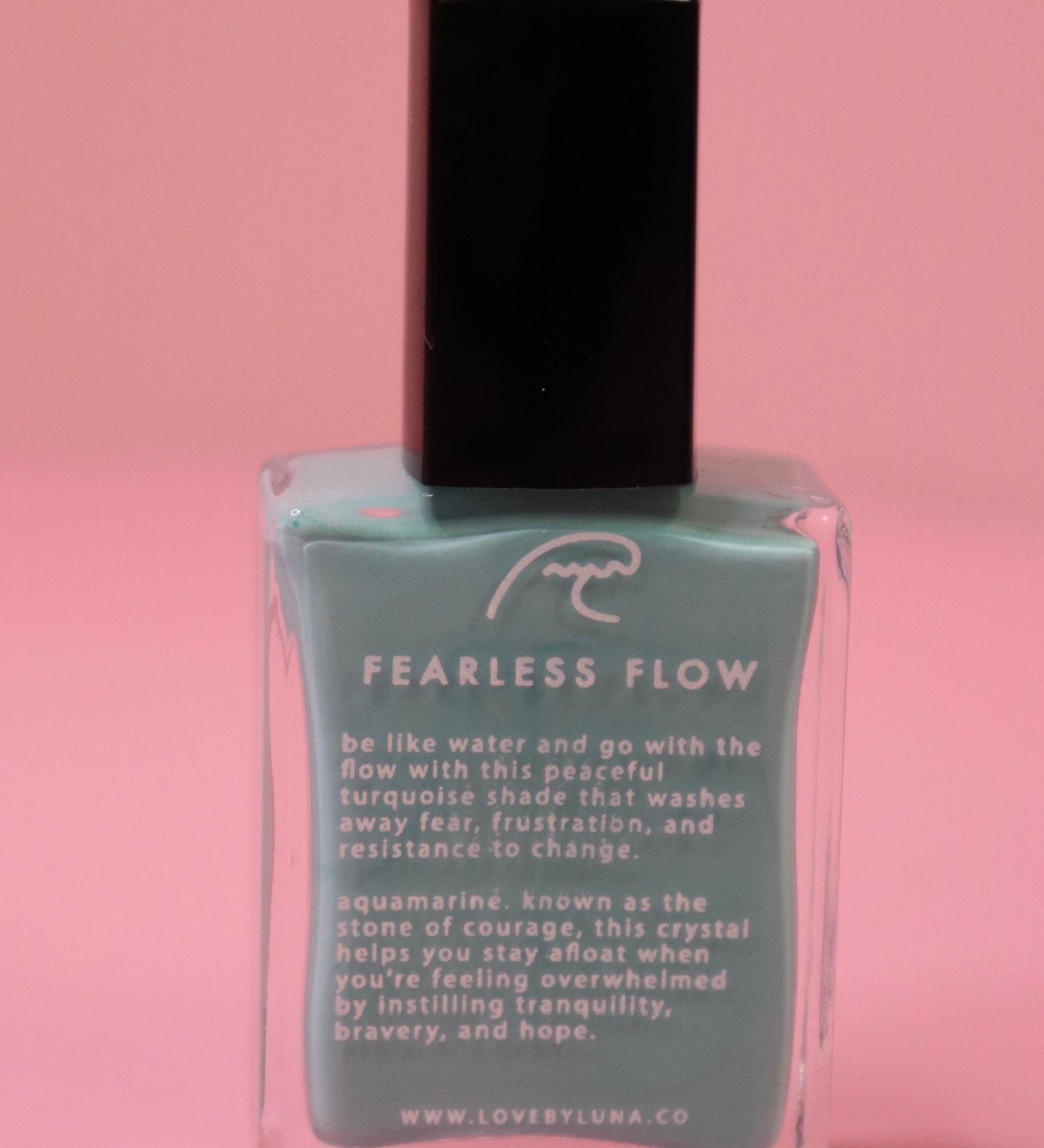 The Fearless Flow Nail Polish with Micronized Aquamarine on a pink background.