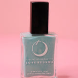 The Fearless Flow Nail Polish with Micronized Aquamarine on a pink background.