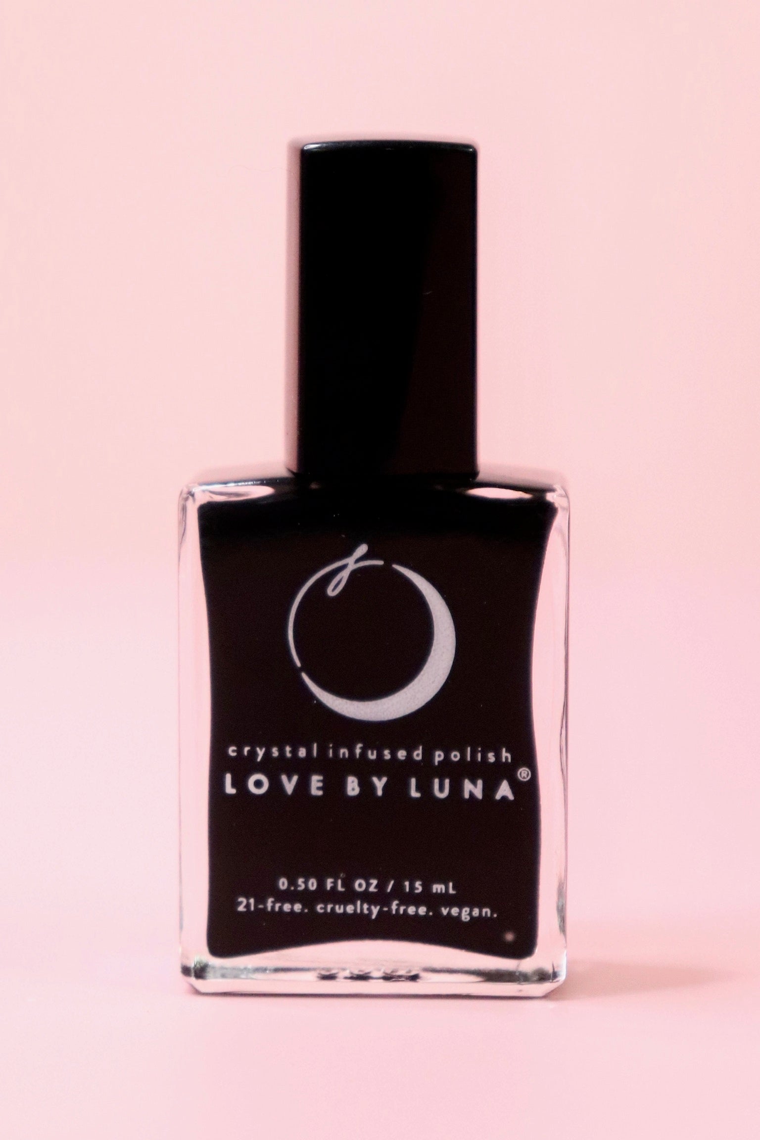 The New Moon Nail Polish with Micronized Selenite, Moonstone, & Clear Quartz on a pink background.