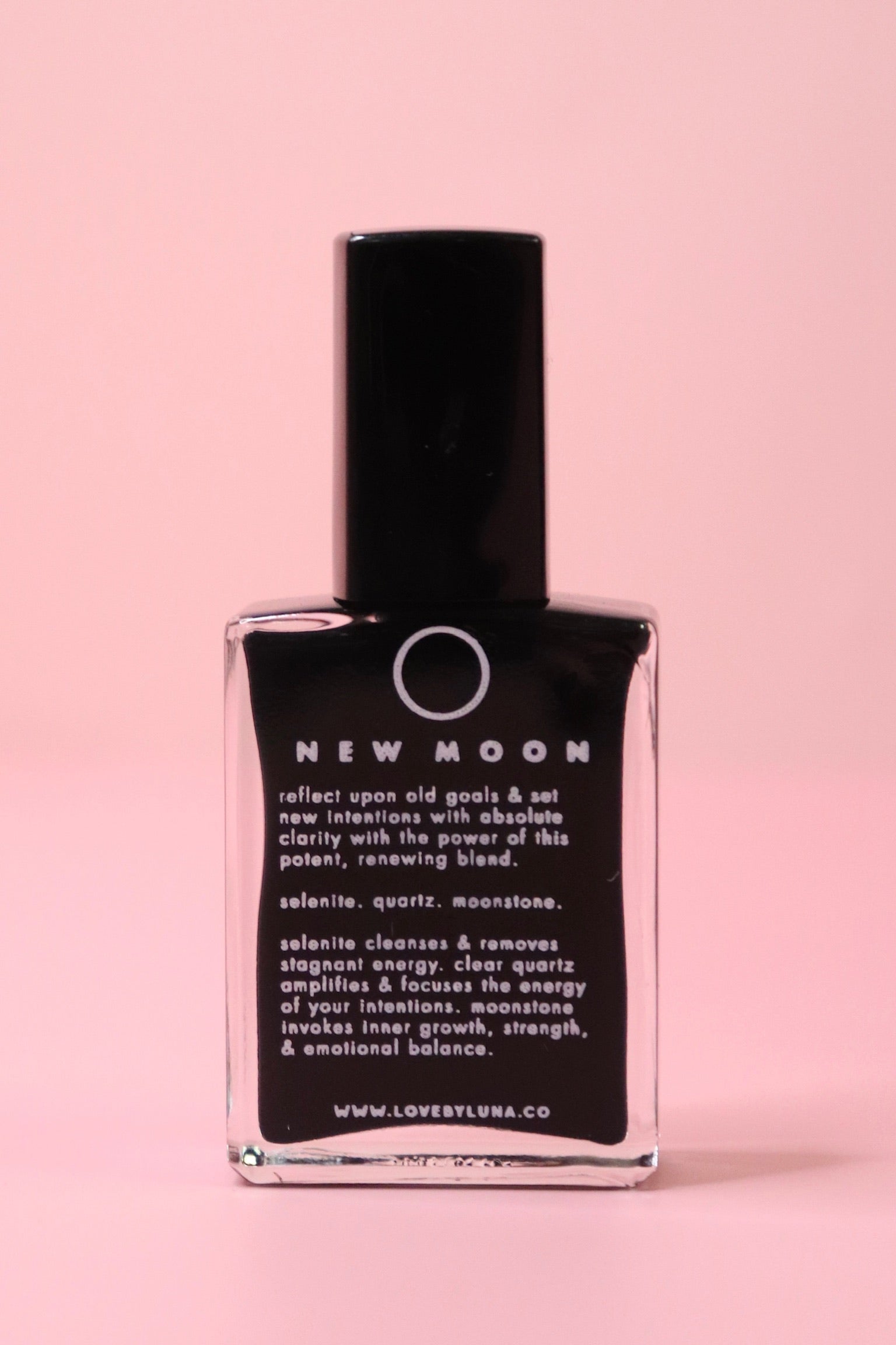 The New Moon Nail Polish with Micronized Selenite, Moonstone, & Clear Quartz on a pink background.