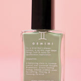 The Gemini Zodiac Nail Polish with Micronized Serpentine on a pink background.