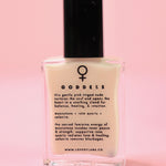 The Goddess Nail Polish with Micronized Rose Quartz, Selenite, & Moonstone on a pink background.