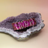 The 'Love' Floral Dragons Blood Sage Smudge Stick 4 in. on an amethyst piece all on a pink and yellow background.