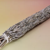 The Jumbo Organic California White Sage - 20" Sage Smudge Stick on a pink and yellow background.