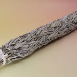 The Jumbo Organic California White Sage - 20" Sage Smudge Stick on a pink and yellow background.