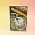 The Mini Smudge Kit with White Sage and Smudging Essentials box on a pink and yellow background.