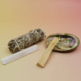The contents of the Mini Smudge Kit with White Sage and Smudging Essentials box on a pink and yellow background.