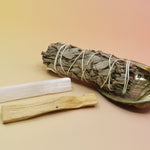 The contents of the Mini Smudge Kit with White Sage and Smudging Essentials box on a pink and yellow background.