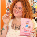 A woman holding the Pippi Longstocking Gold Coins bag with one candy in her left hand.