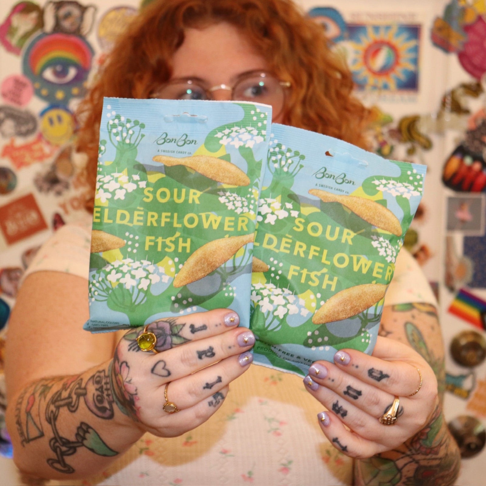 A woman holding two bags of the BonBon NYC Sour Elderflower Fish - Swedish Candy.