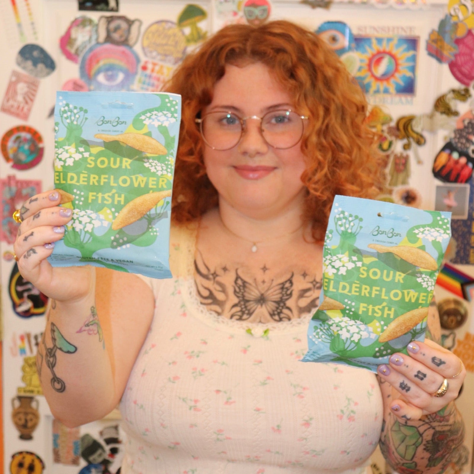 A woman holding two bags of the BonBon NYC Sour Elderflower Fish - Swedish Candy.