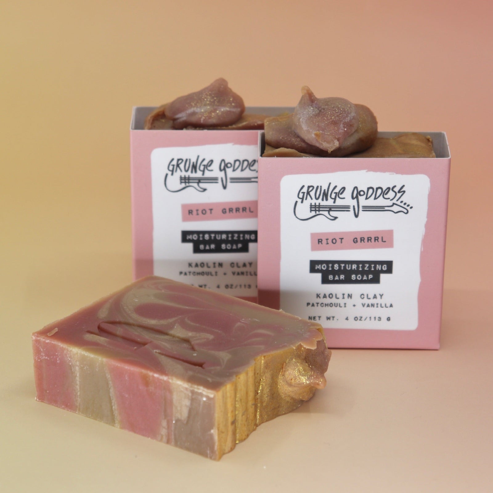 Three of the Riot Grrrl - Moisturizing Bar Soaps on a peach-colored background.