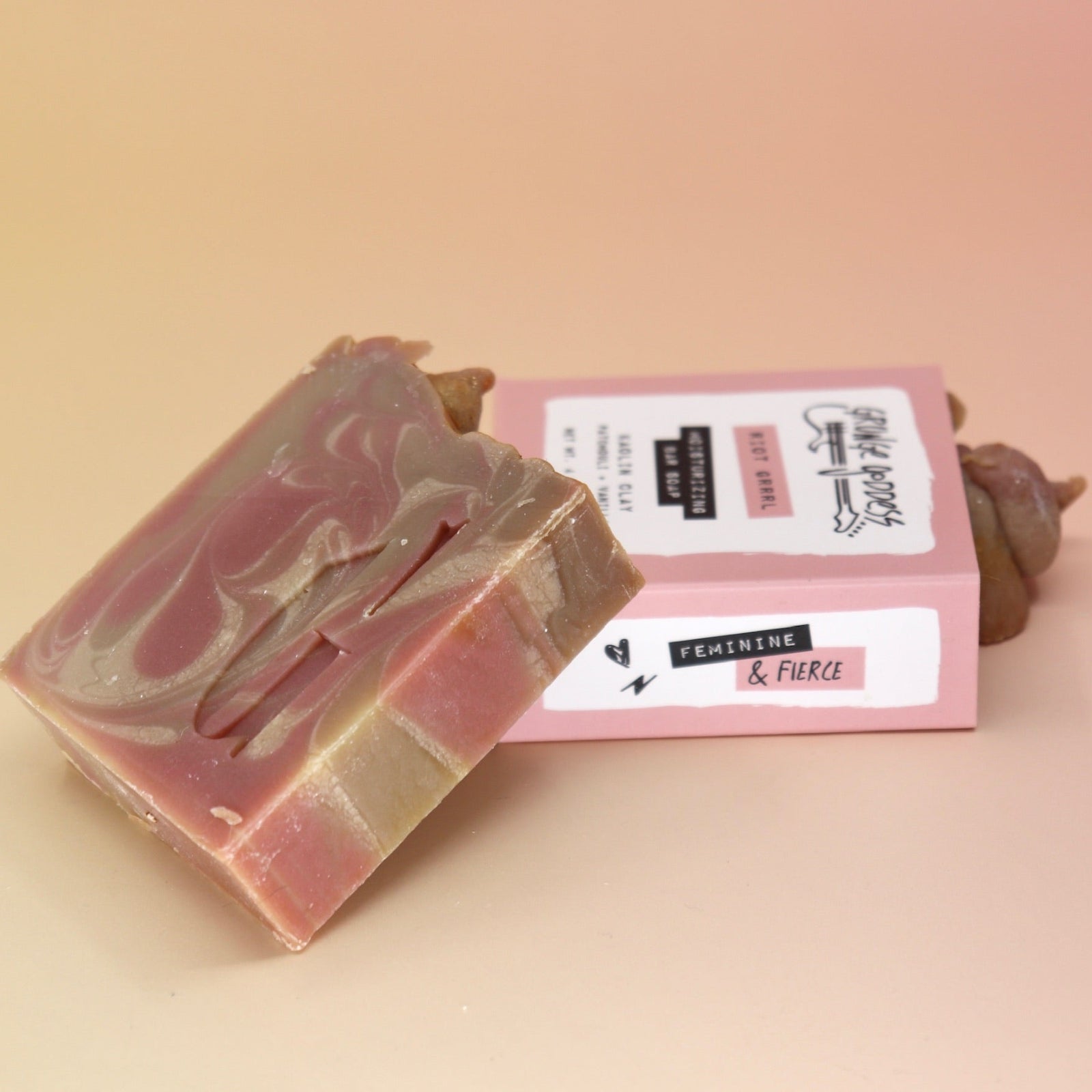 Two of the Riot Grrrl - Moisturizing Bar Soaps on a peach-colored background.