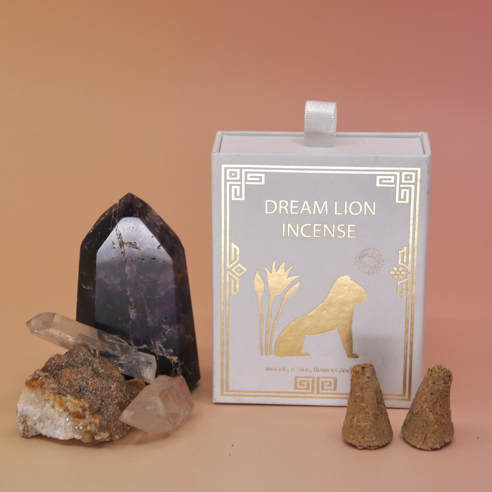 The Nine Treasures Incense Cones box next to two crystal pieces with two incense cones in front of it all on a pink and yellow background.