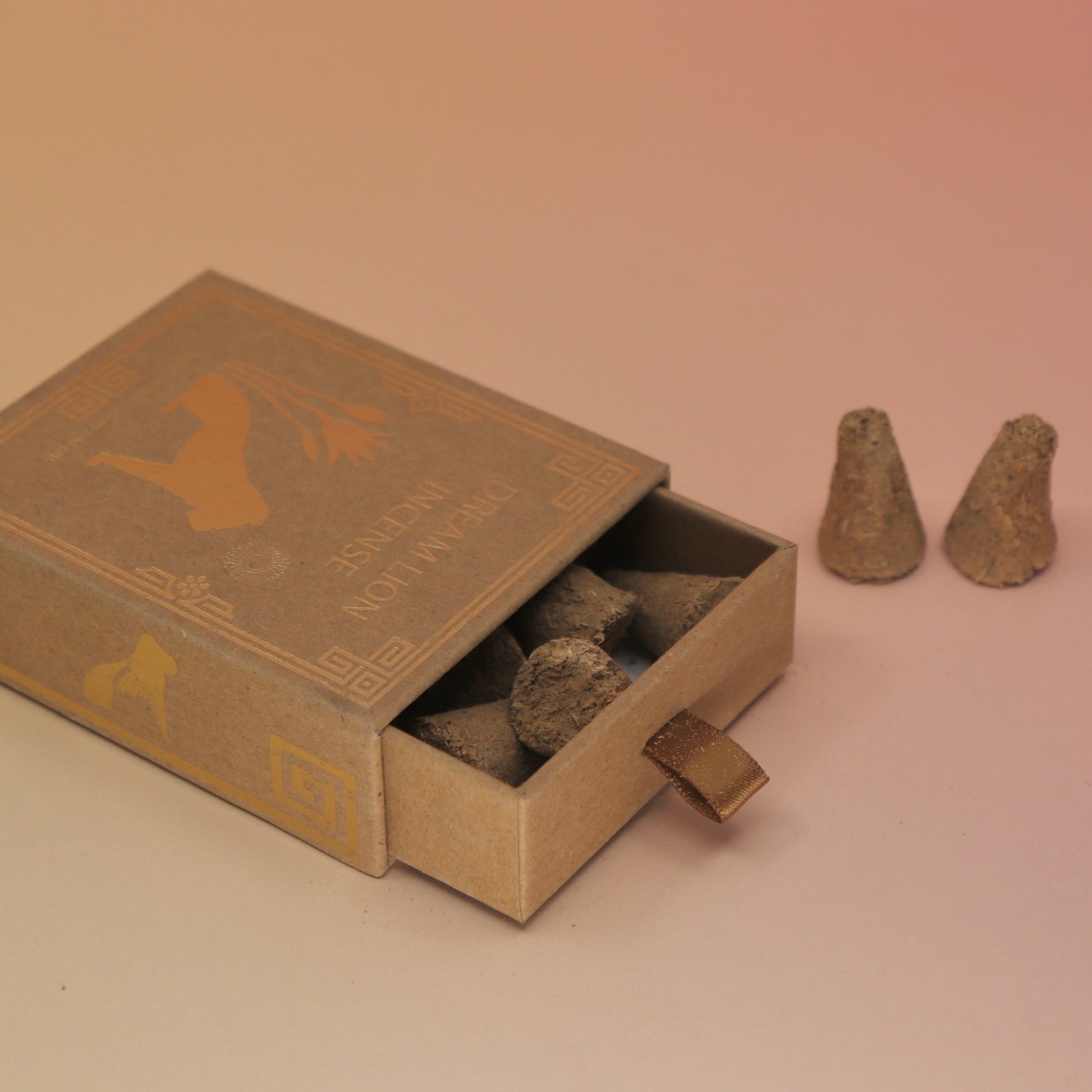 The Creative Imagination Incense Cones box lying down with two incense cones next to it, all on a pink and yellow background.