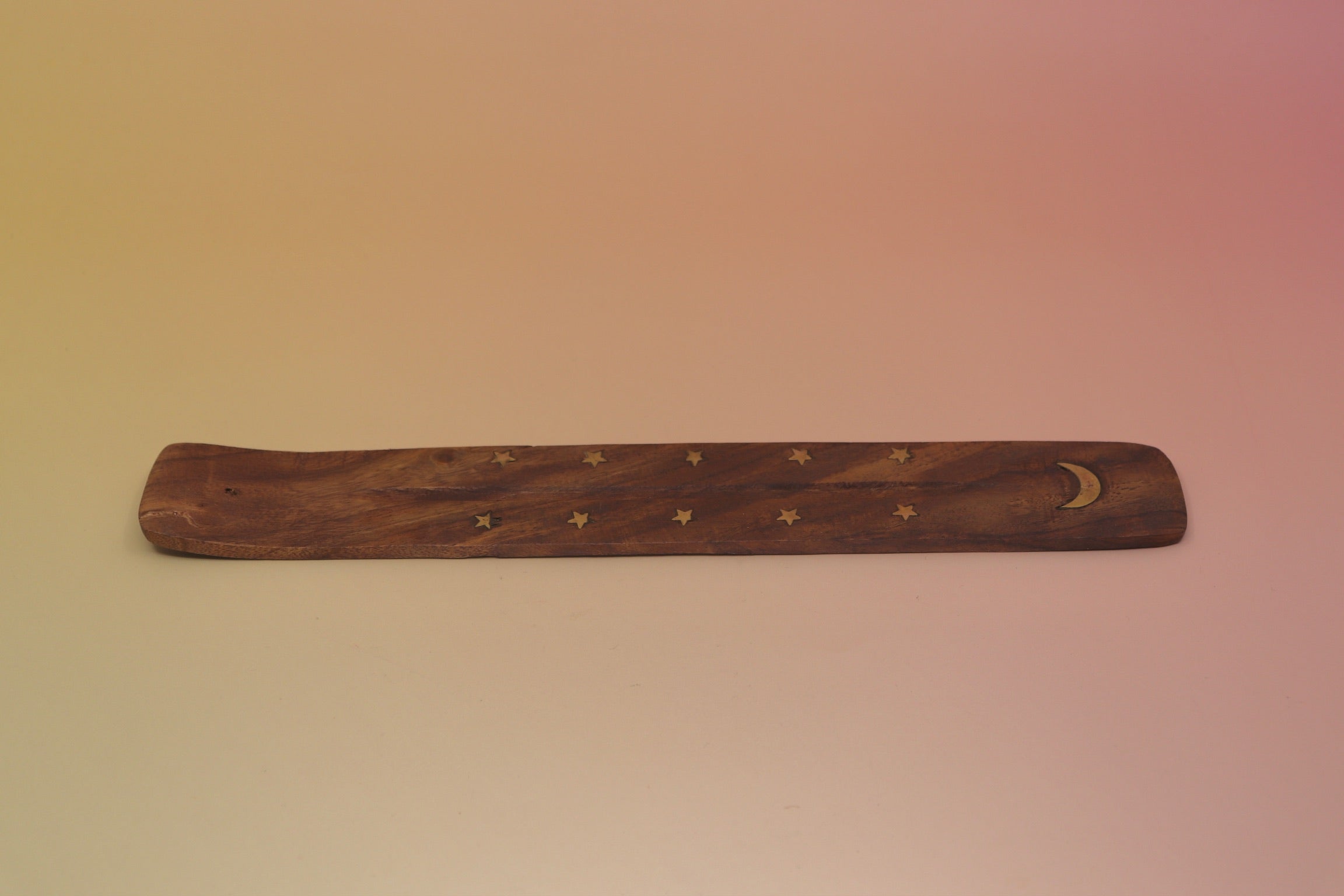 The Moon Wooden Incense Burner on a pink and yellow background.