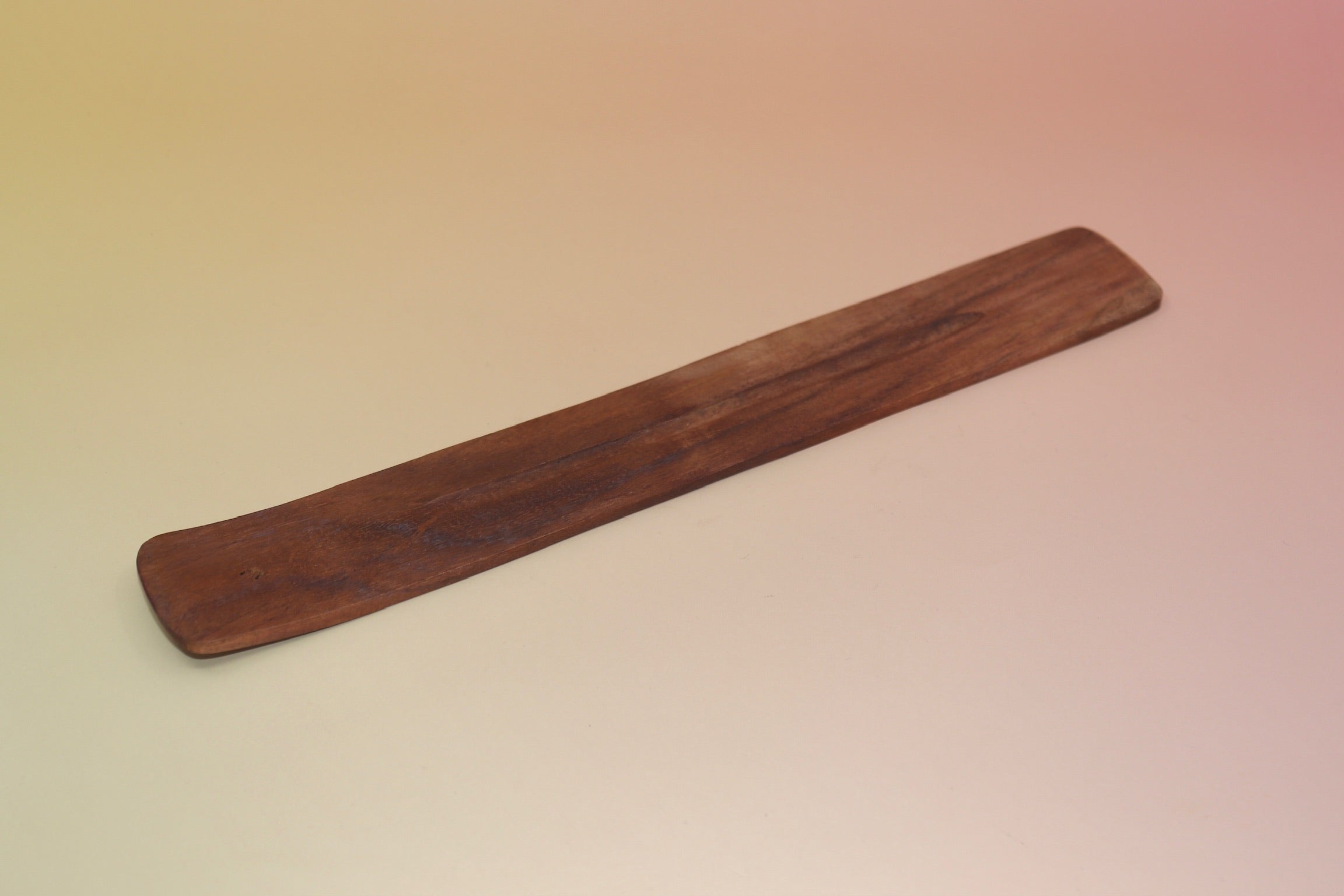 The Plain Wooden Incense Burner on a pink and yellow background.